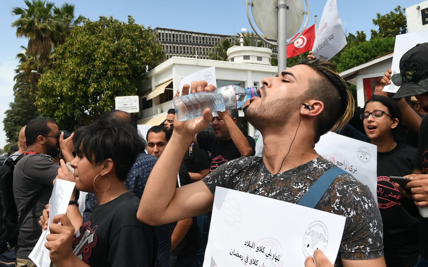 Un Tunisien boit de l'eau lors d'une manifestation, pour dénoncer les arrestations de personnes qui ne jeûnent pas pendant le Ramadan, à Tunis,  le 27 mai 2018 (AFP)