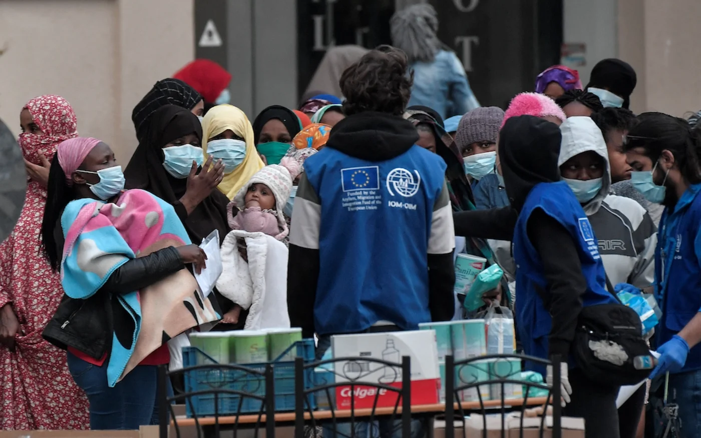 Des réfugiés font la queue pour récupérer des colis alimentaires, à Kranídi, en Grèce, le 21 avril 2020 (AFP)