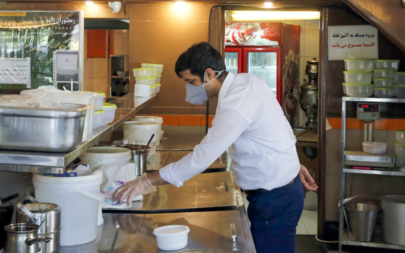Un employé attend des clients, dans un restaurant, à Téhéran, le 26 mai 2020 (AFP)