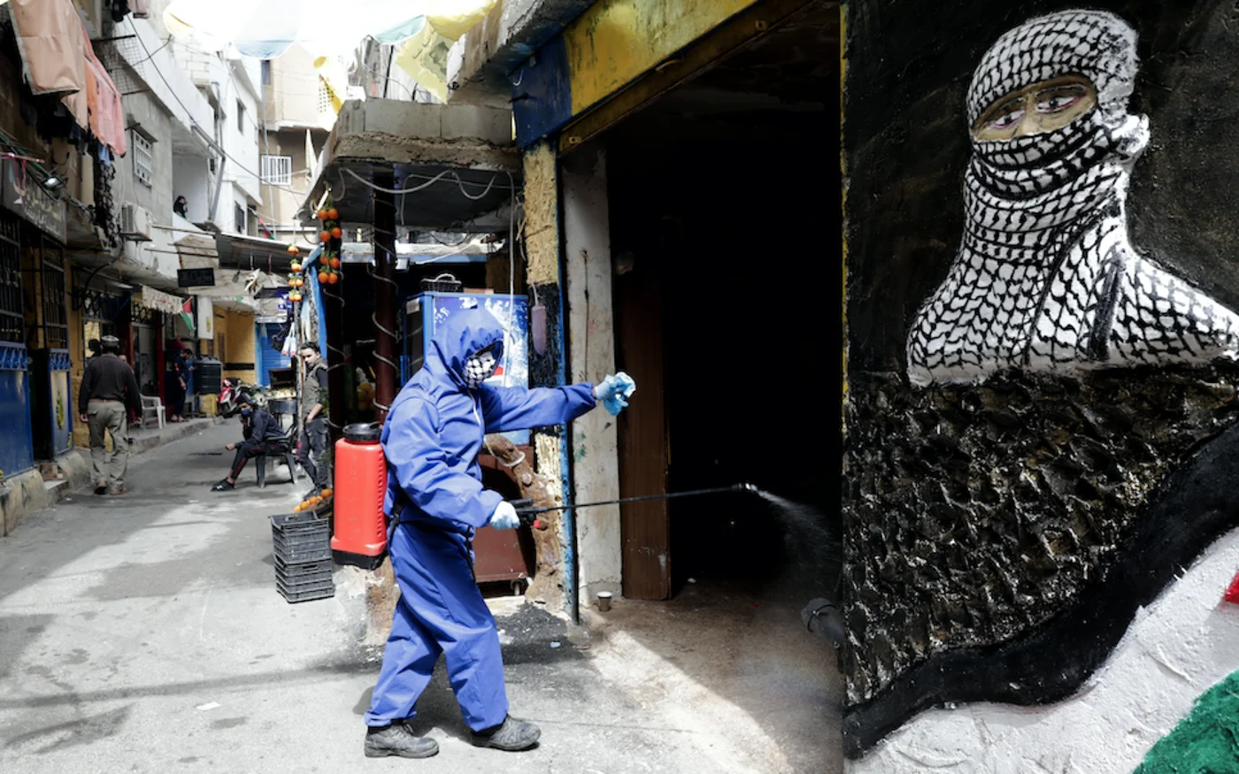 Opération de désinfection dans les rues du camp de réfugiés palestiniens de Chatila, à Beyrouth, le 24 mars 2020 (AFP) 