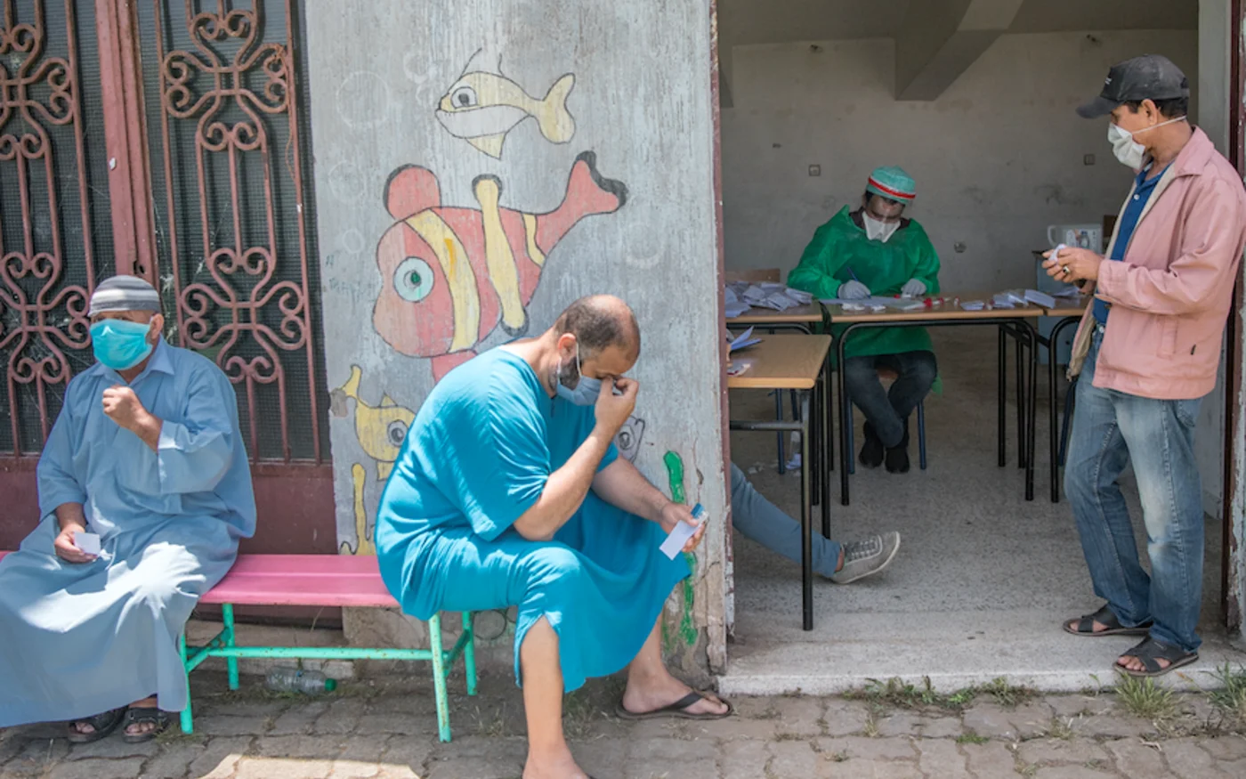 Des ouvriers attendent avant de se faire dépister pour le coronavirus, à Rabat, le 27 mai 2020 (AFP)