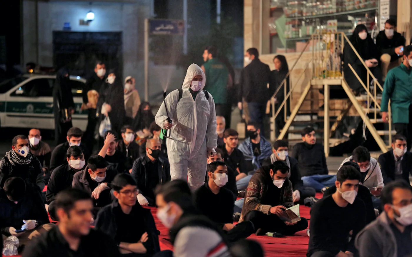 Des Iraniens assistent aux prières du Laylat al-Qadr, l'une des nuits les plus saintes du Ramadan, devant une mosquée de Téhéran, le 13 mai 2020 (AFP)