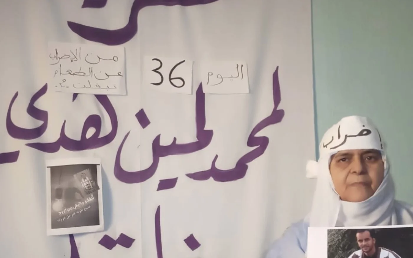 La mère de Mohamed Haddi devant un poster réclamant la libération de son fils (Document fourni/MEE)
