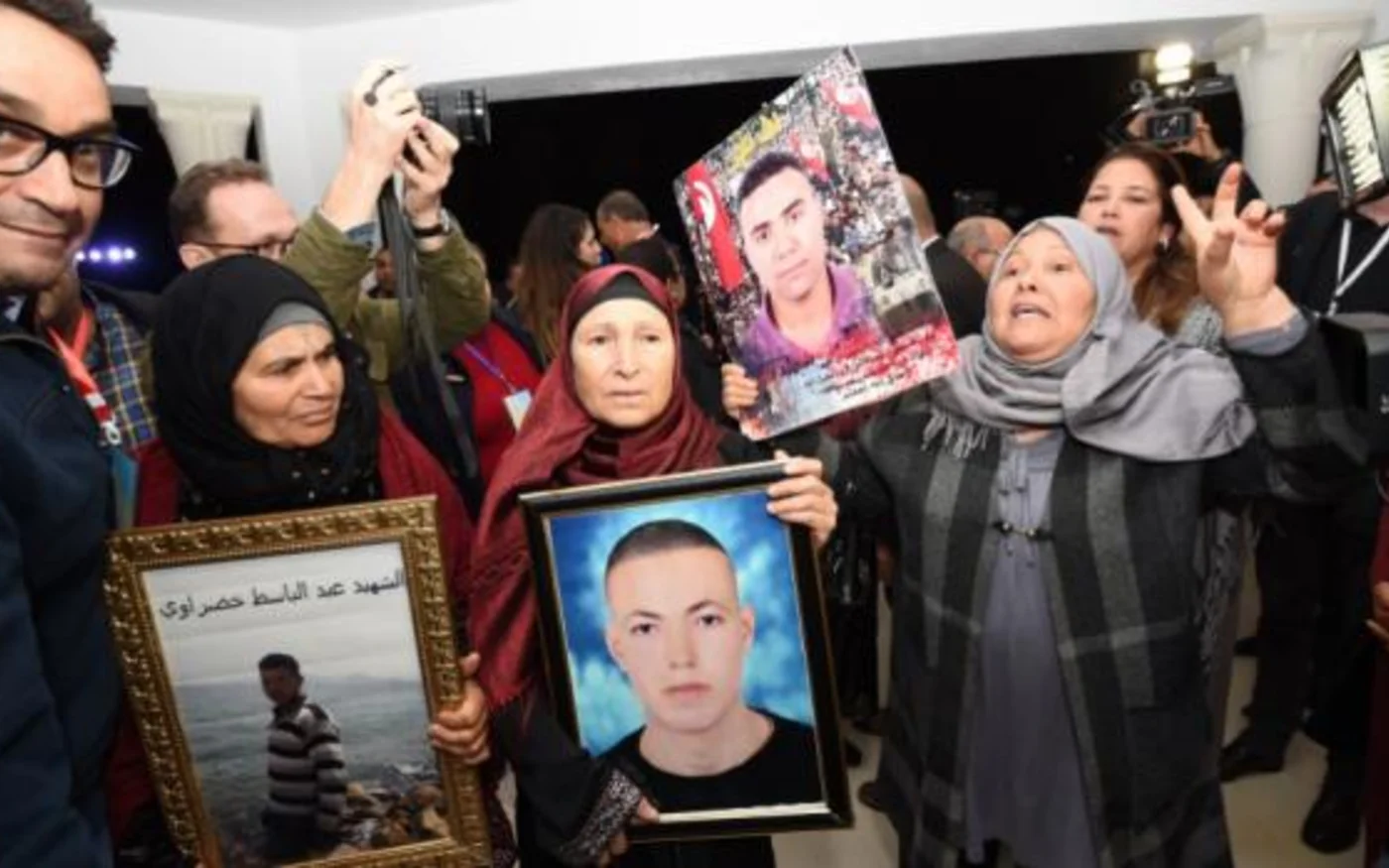 En Tunisie, des mères de victimes de la torture brandissent les portraits de leurs fils à leur arrivée pour une audience devant l’Instance vérité et dignité à Tunis, le 17&nbsp;novembre&nbsp;2016 (AFP)