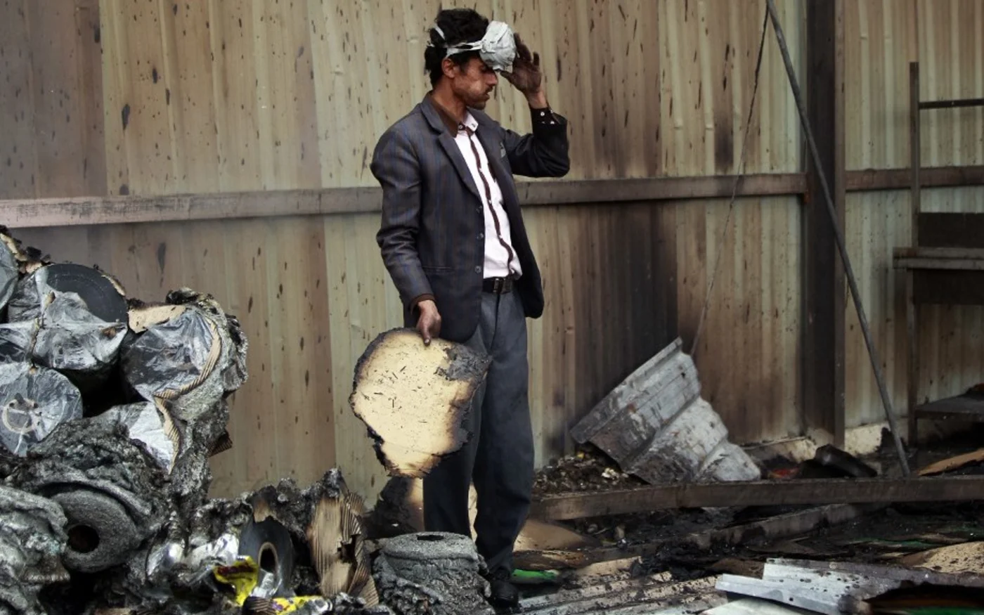  An employee checks the damage from a Saudi-led coalition attack that killed over a dozen of his colleagues at the Al-Aqel factory in Sanaa in August 2016 (Mohammed Huwais/AFP)