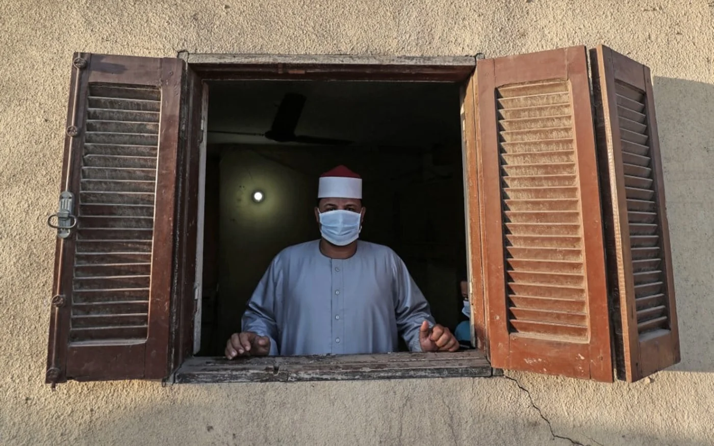 L’imam d’une mosquée locale se tient derrière une fenêtre ouverte de style sheesh (AFP)