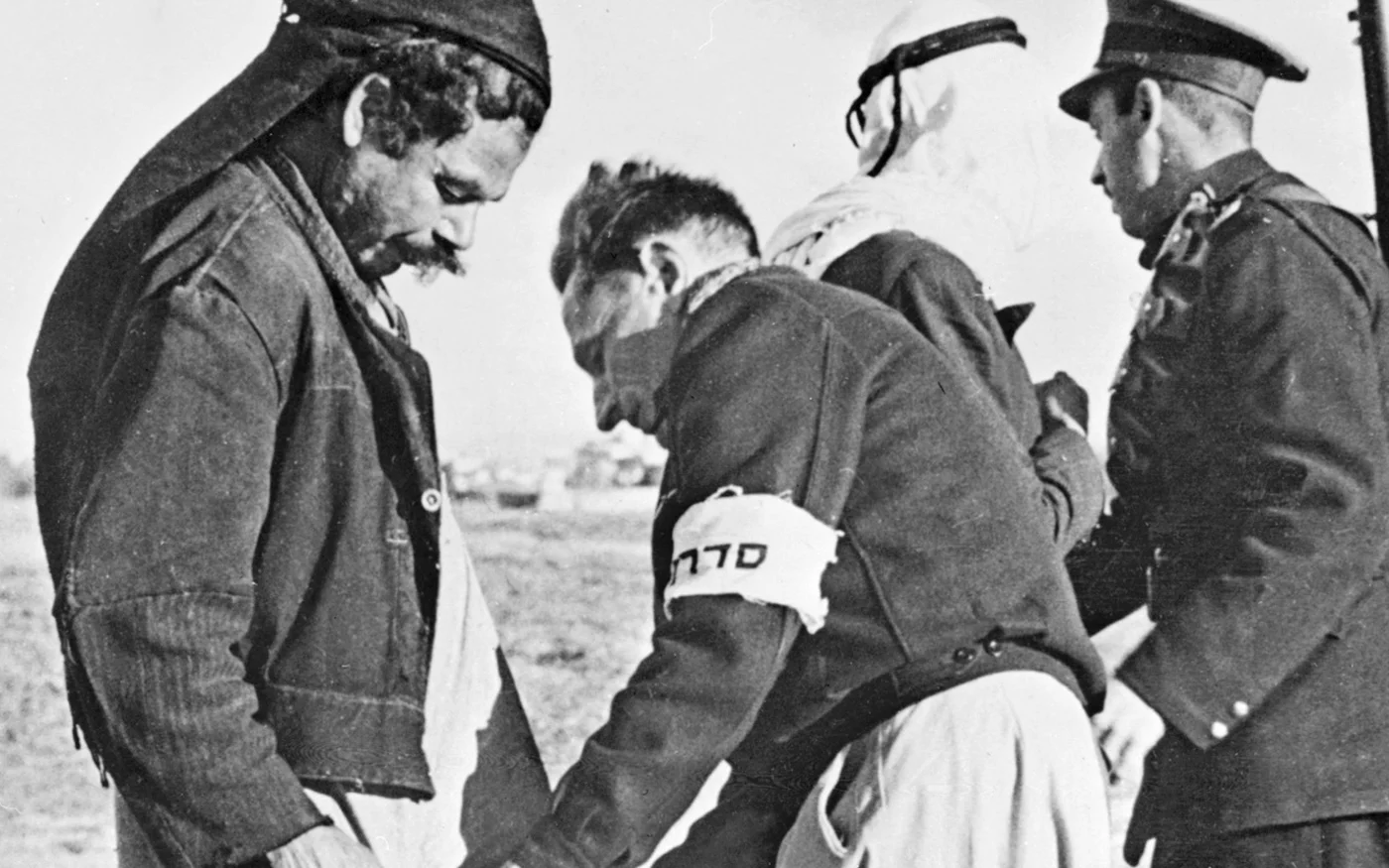 Des membres de la Haganah fouillent deux Palestiniens à la porte de Tel Aviv, le 20 janvier 1948 (AFP)