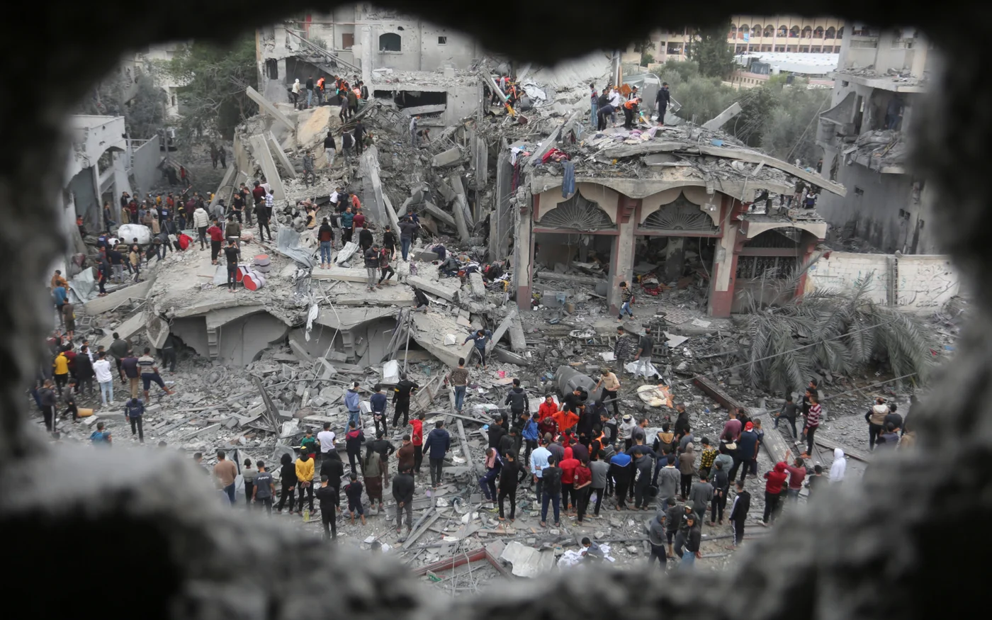 Palestinians search for survivors of the Israeli bombing in Rafah, Gaza on 22 November 2023 (AP)