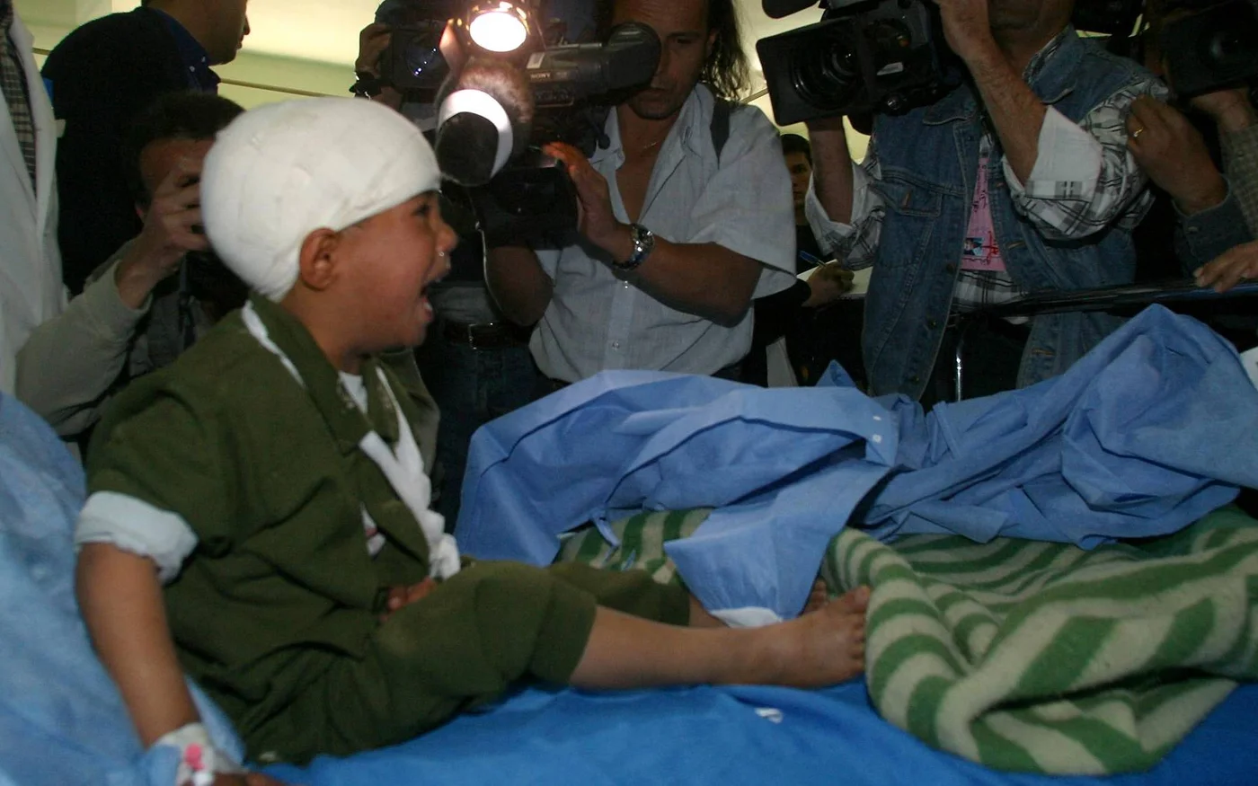 Un enfant irakien blessé pleure devant des photographes et des cameramen lors d’une visite effectuée par le ministère de l’Information à l’hôpital al-Yarmouk de Bagdad, le 22&nbsp;mars&nbsp;2003 (AFP)