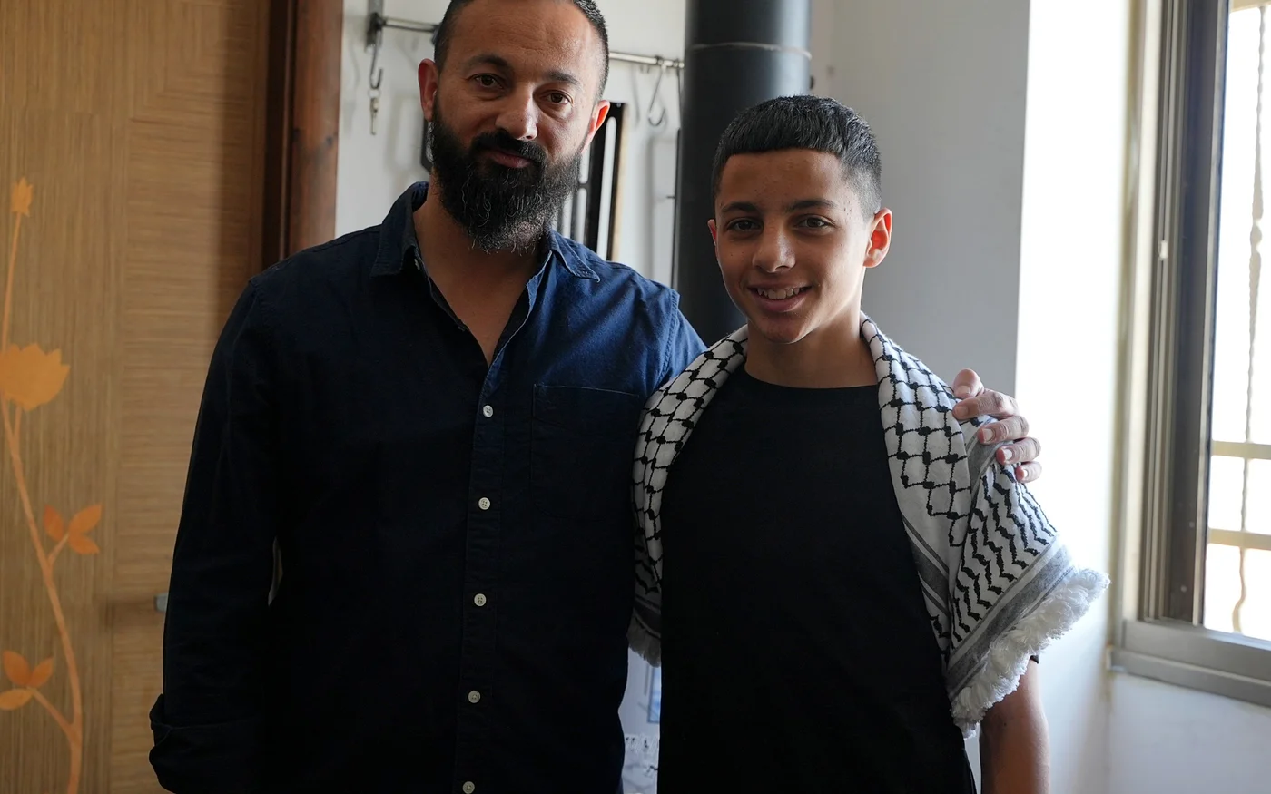 Athal (à droite) a retrouvé sa maison et les bras aimants de son père (à gauche) et de sa mère, le 27 avril 2022 (MEE/Akram al-Waara)