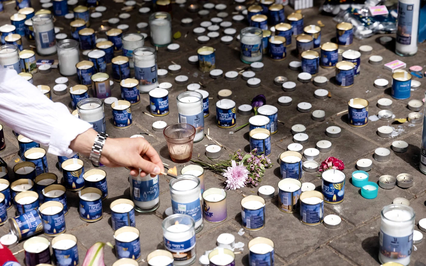 Des Israéliens allument des bougies en souvenir des victimes de la fusillade rue Dizengoff, dans le centre de Tel-Aviv (MEE/Oren Ziv)
