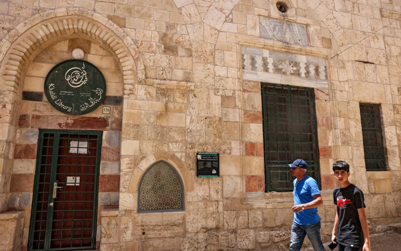 Des Palestiniens passent devant la bibliothèque Khalidi dans la vieille ville de Jérusalem (AFP/Ahmad Gharabli)