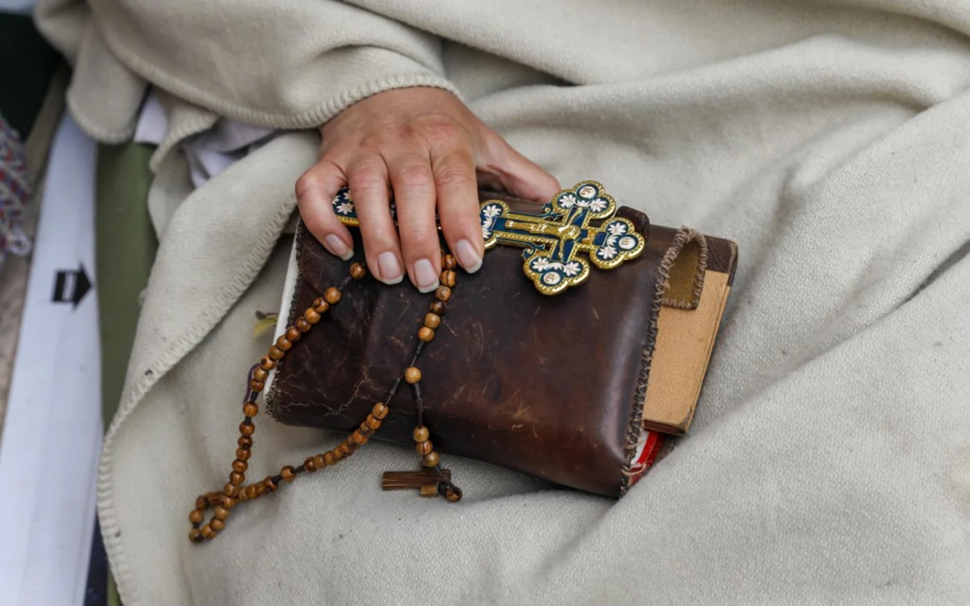 Un homme tient un livre de prières dans la vieille ville de Jérusalem lors du Vendredi saint orthodoxe (AFP)