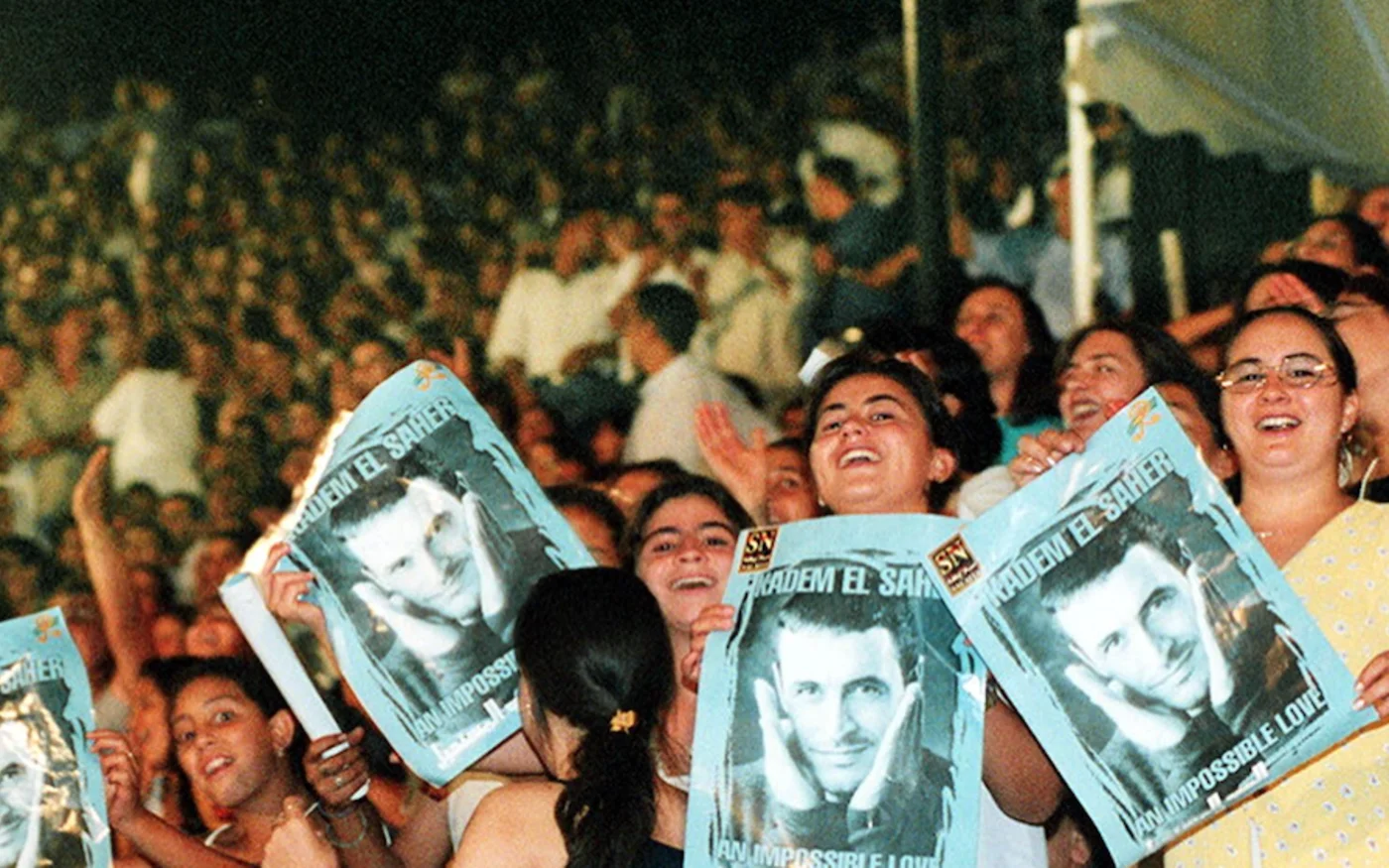 Des femmes tiennent des portraits de la star irakienne, Kazem al-Saher, au Théâtre Romain à Carthage, le 05 août (AFP)