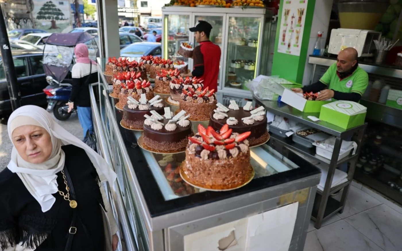 Une femme passe devant des gâteaux présentés devant une pâtisserie au prix de deux millions de livres libanaises (environ 20 dollars) à l’occasion de la Fête des mères dans la banlieue sud de Beyrouth, le 21 mars 2023 (AFP)