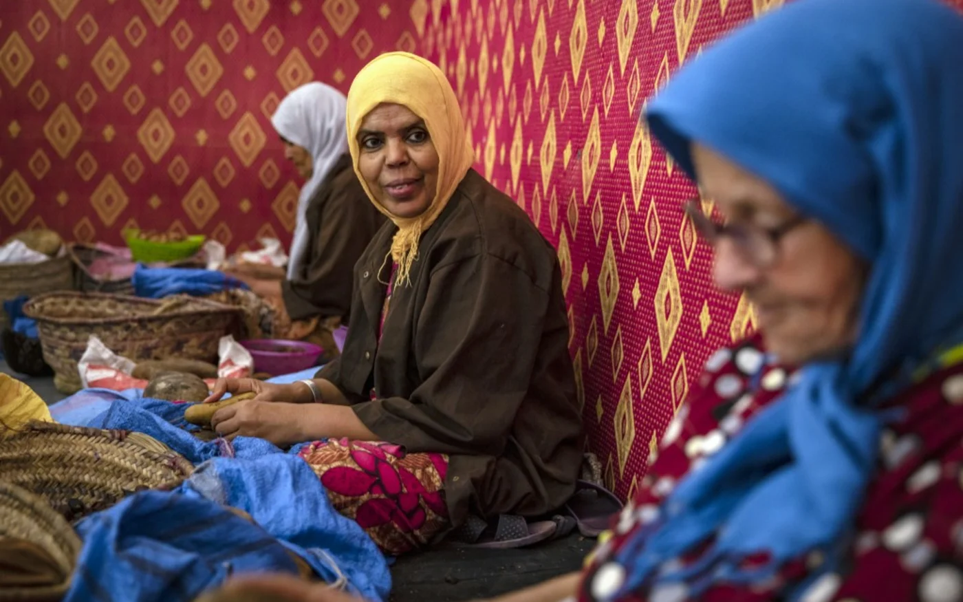 Des femmes décortiquent des noix d’argan pour fabriquer de l’huile près d’Essaouira, ville côtière de l’Atlantique ouest du Maroc, le 15 octobre 2022 (AFP/Fadel Senna)