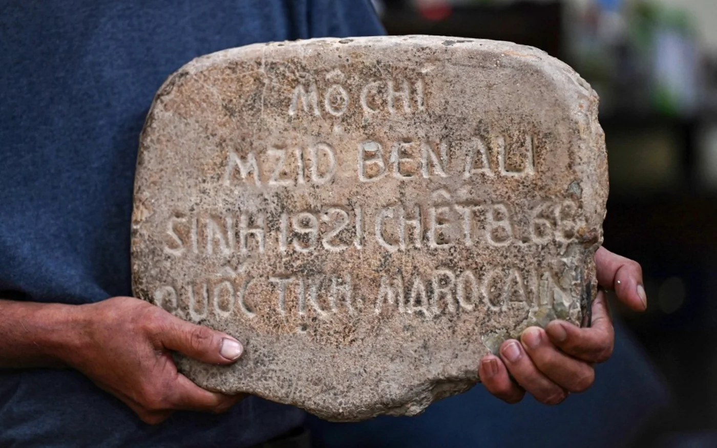 Cette photo prise le 11 avril 2024 montre Le Tuan Binh portant la pierre tombale de son père chez lui, dans la province de Phu Tho, au nord du Vietnam (Nhac Nguyen/AFP)