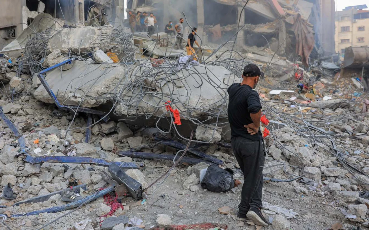 Des Palestiniens inspectent les dommages après une frappe aérienne israélienne sur un quartier résidentiel de Gaza (MEE/Mohammed al-Hajjar)