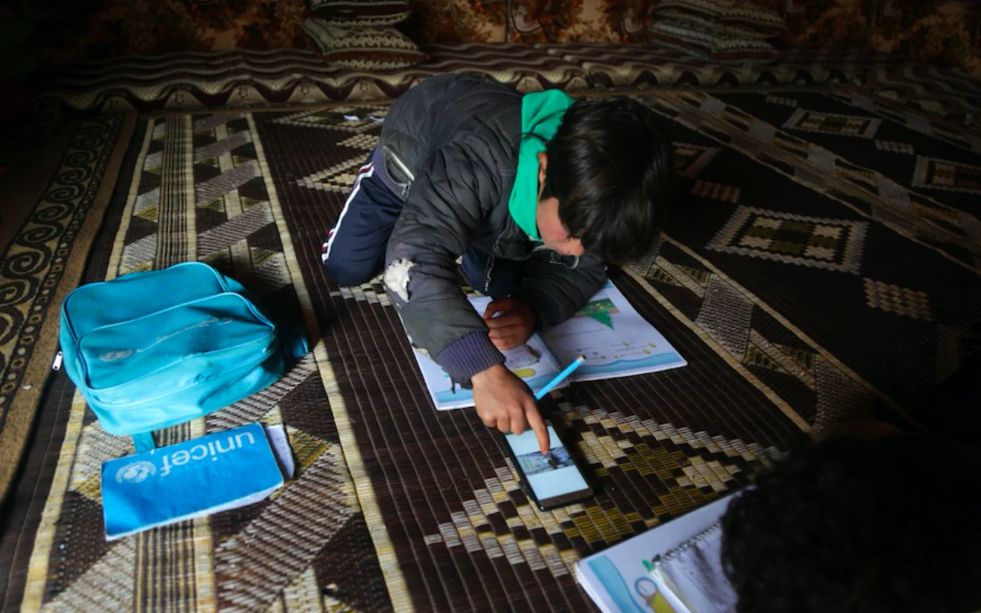 Un élève suit en ligne une leçon à l'intérieur d'une tente, dans un camp de déplacés Syriens dans le village de Kafr Yahmoul, dans le nord-ouest d'Idlib, le 3 avril 2020 (AFP)