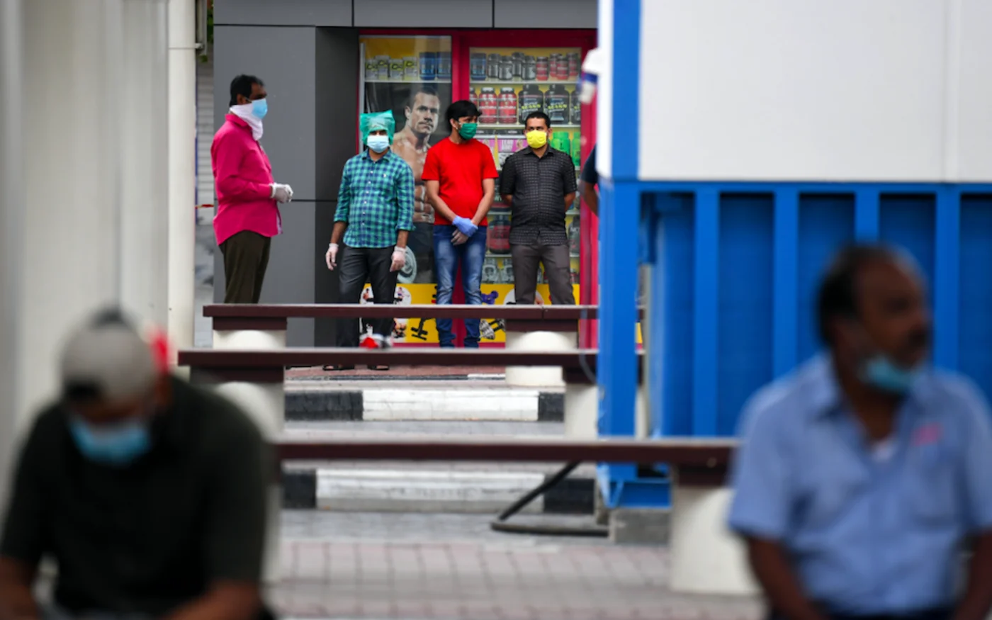 Des travailleurs migrants font la queue dans la zone de Naif de l'émirat du Golfe de Dubaï, le 15 avril 2020 (AFP)