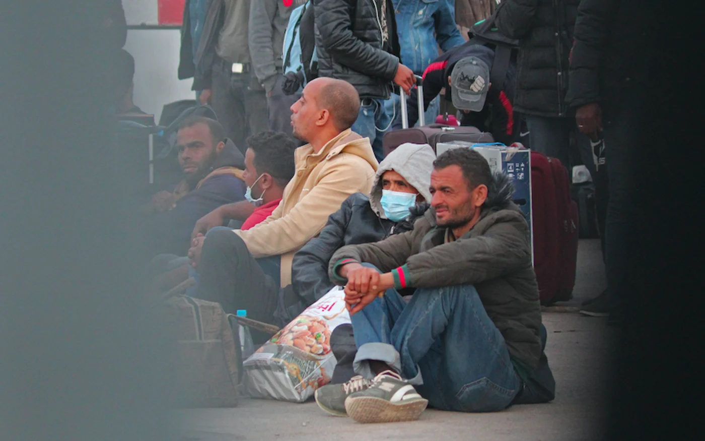 Des travailleurs tunisiens bloqués en Libye sont photographiés alors qu'ils rentrent en Tunisie au poste frontière de Ras Jedir, le 20 avril 2020 (AFP)