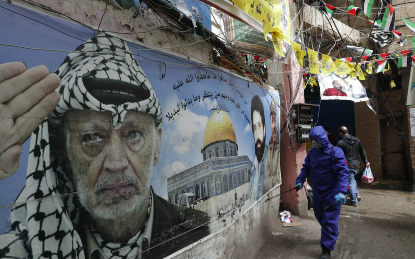 Un bénévole d'une association palestinienne pulvérise du désinfectant, dans le camp de réfugiés palestiniens de Chatila, à Beyrouth, le 24 mars 2020 (AFP)