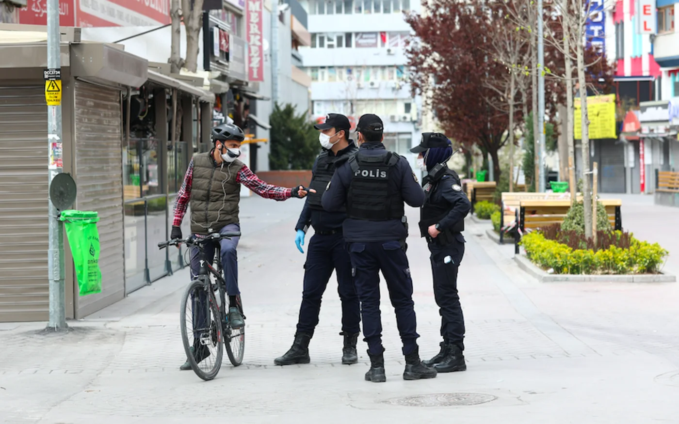 Des policiers contrôlent un cycliste dans la rue Karanfil, à Ankara, le 11 avril 2020 (AFP)