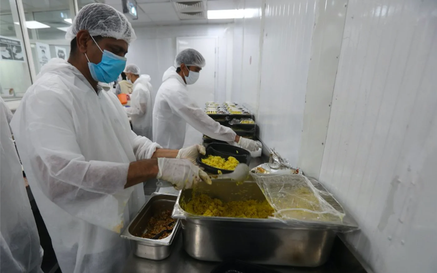 Des bénévoles préparent des colis alimentaires pour les travailleurs migrants, à Doha, le 16 avril 2020 (AFP)