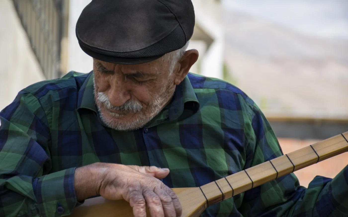 Zeynel Batar joue une chanson zaza sur son baglama dans son village du Dersim (MEE/Nick Ashdown)