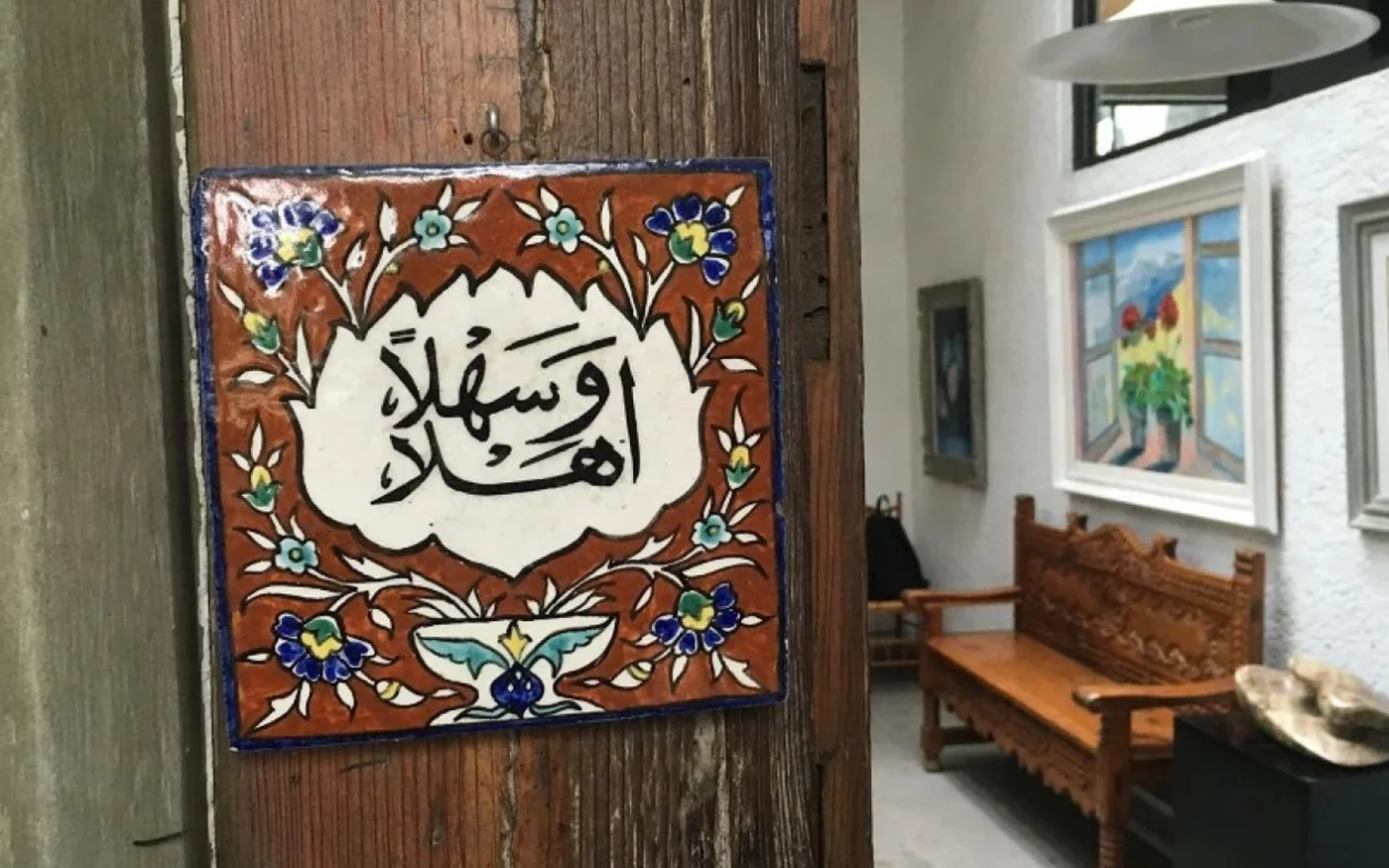 Un carreau sur lequel on peut lire en arabe « Ahlan wa Sahlan » (« Bienvenue ») accueille les visiteurs chez Aida Jury De Saad (MEE/Alex Shams)