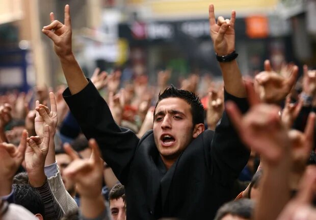 Les partisans du parti d’extrême droite MHP scandent des slogans en faisant le « signe du loup » (AFP)