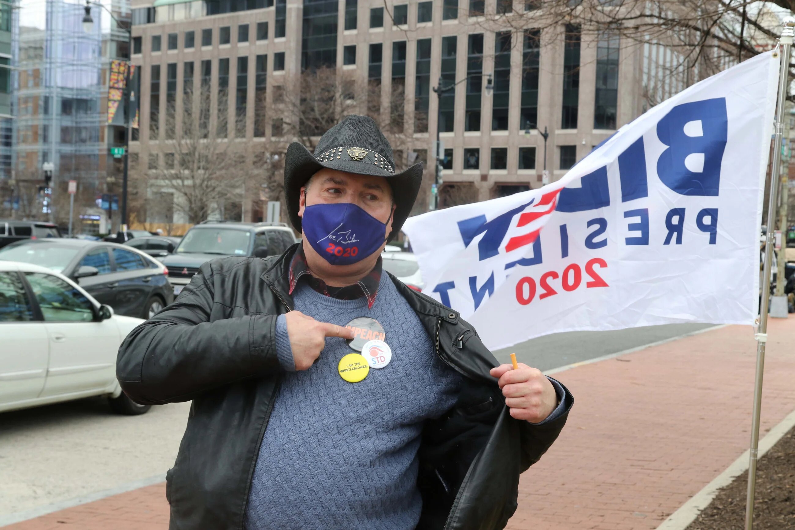 Joe Biden supporter David Bates points to an "Impeach" button he is wearing, referring to former President Donald Trump.