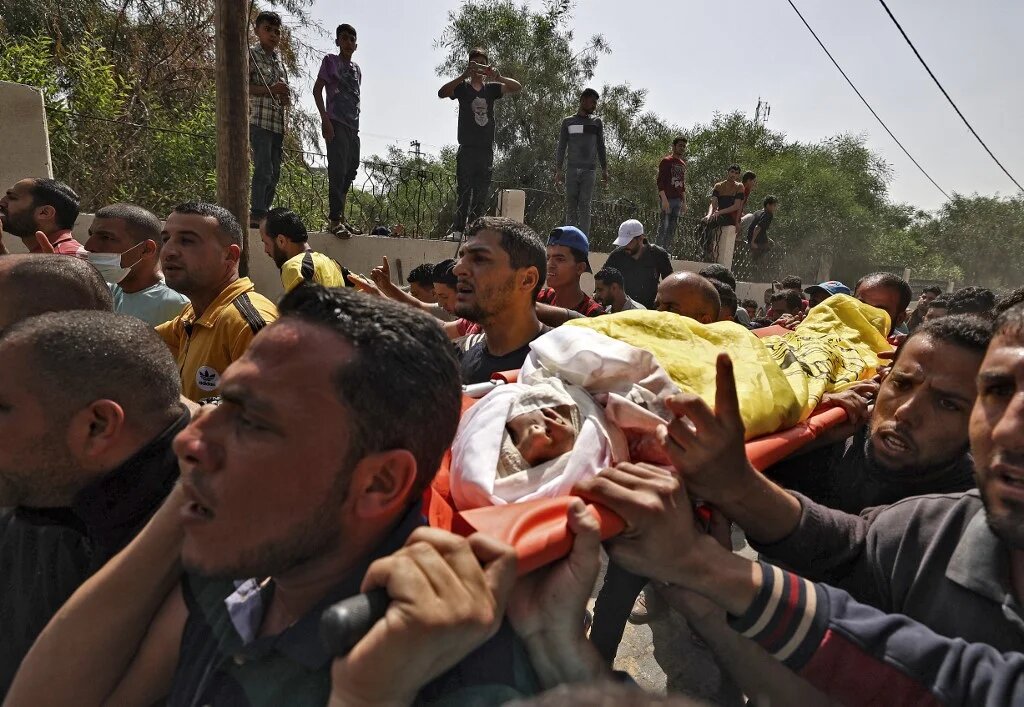 Des Palestiniens portent le corps de Hussein Hamad, 11 ans, lors de ses funérailles à Beit Hanoun, dans le nord de la bande de Gaza, le 11 mai 2021 (AFP)
