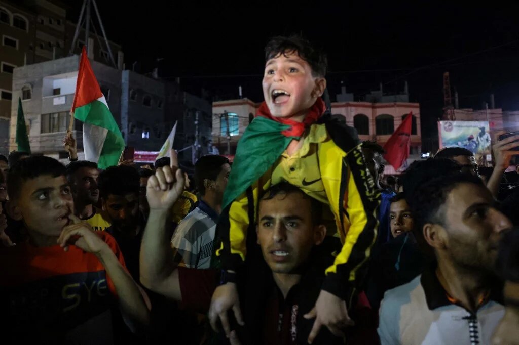 A child screams with joy as people come outside to celebrate the beginning of the ceasefire in Gaza City