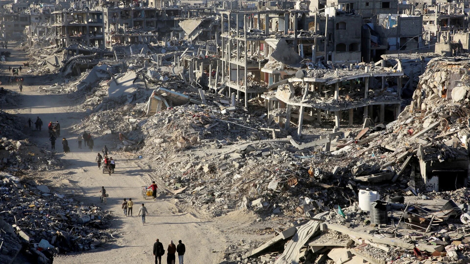 Palestinians walk past the rubble of houses and buildings destroyed during the war, following a ceasefire between Israel and Hamas, in Rafah in the southern Gaza Strip, January 20, 2025. REUTERS/Hatem Khaled TPX IMAGES OF THE DAY