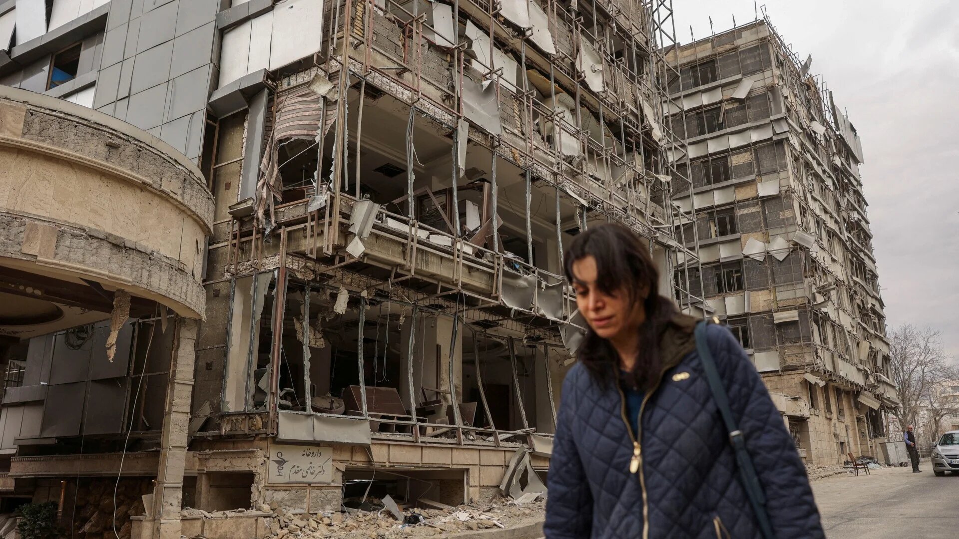 A woman walks on the street following an Israeli and U.S. strike on Gandhi Hotel Hospital, amid the U.S.-Israel conflict with Iran, in Tehran