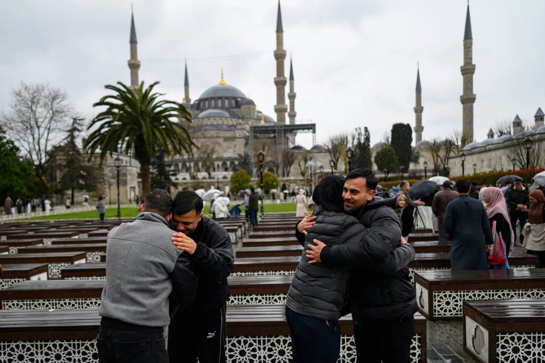 Muslims greet each other outside the Blue Mosque as worshippers attend the morning prayers celebrating Eid al-Fitr in Istanbul, Turkey (Yasin Akgul/AFP)