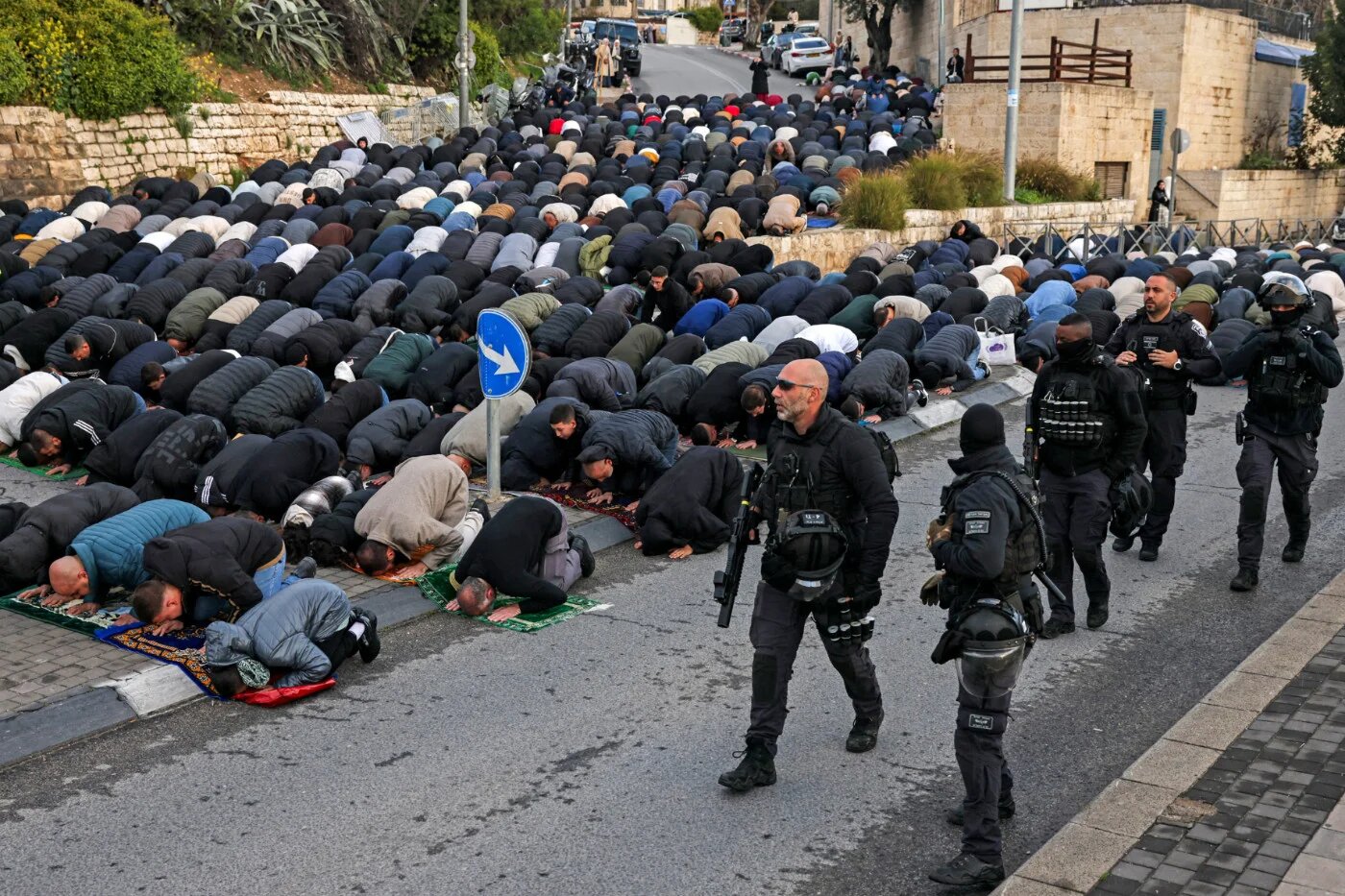 Israeli security forces walk past Muslim worshippers gathering outside Jerusalem's Old City walls to attend attend early morning prayers for Eid al-Fitr, 20 March 2026 (Ahmad Gharabli/AFP)