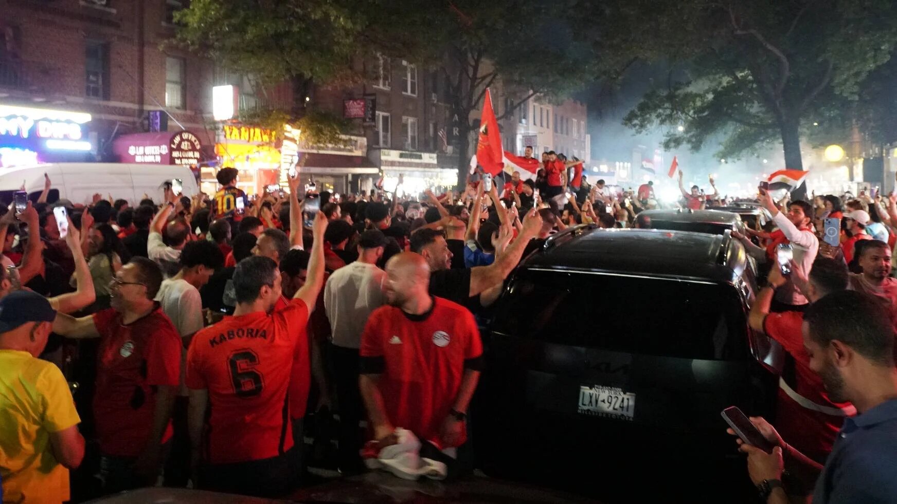 Egyptian fans flood Steinway Avenue in Queens after their team's historic victory over New Zealand (Azad Essa/MEE)