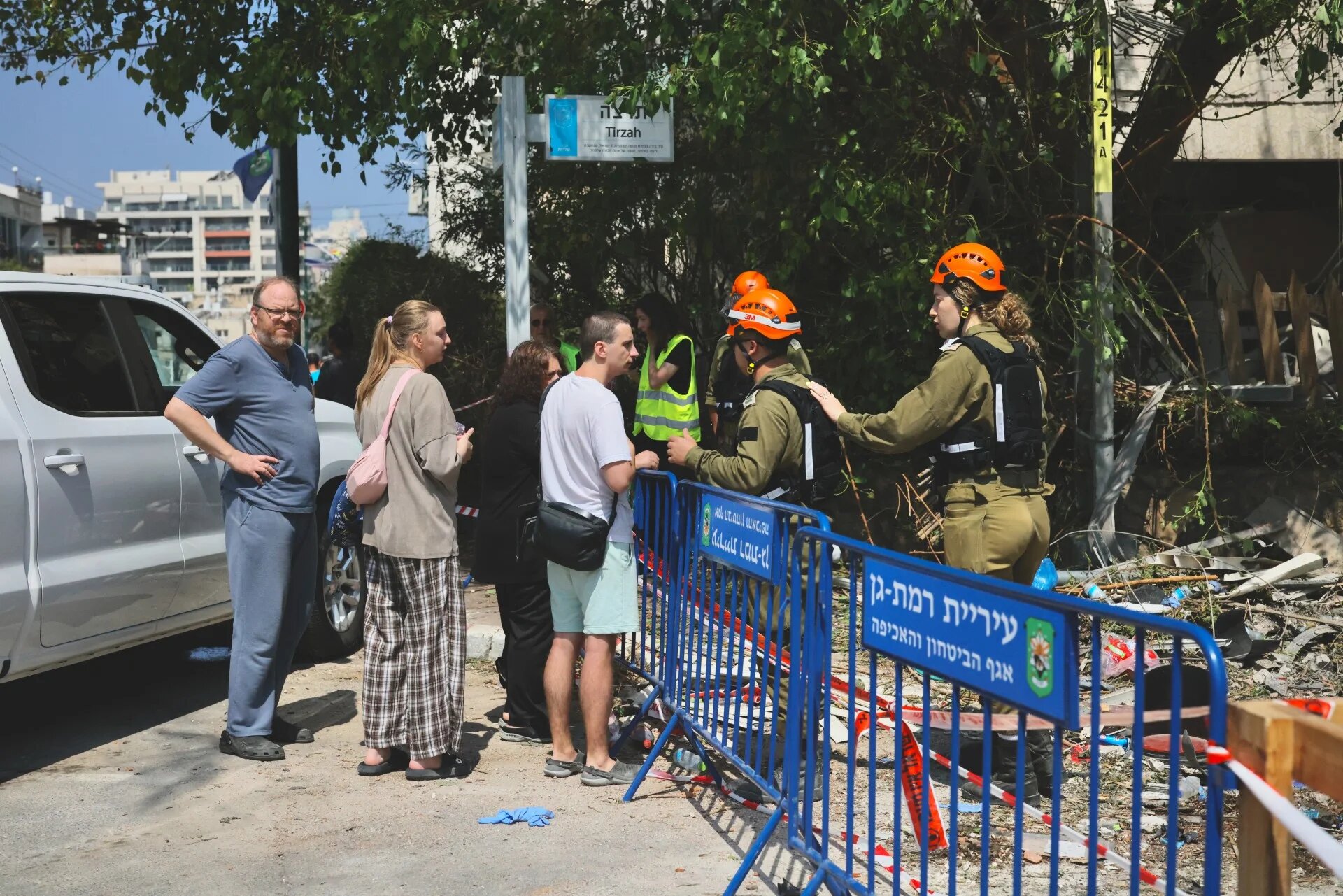 People walk through a site hit by a missile fired from Iran, south of Tel Aviv, on 14 June 2025 (Middle East Eye/Faiz Abu Rmelah)