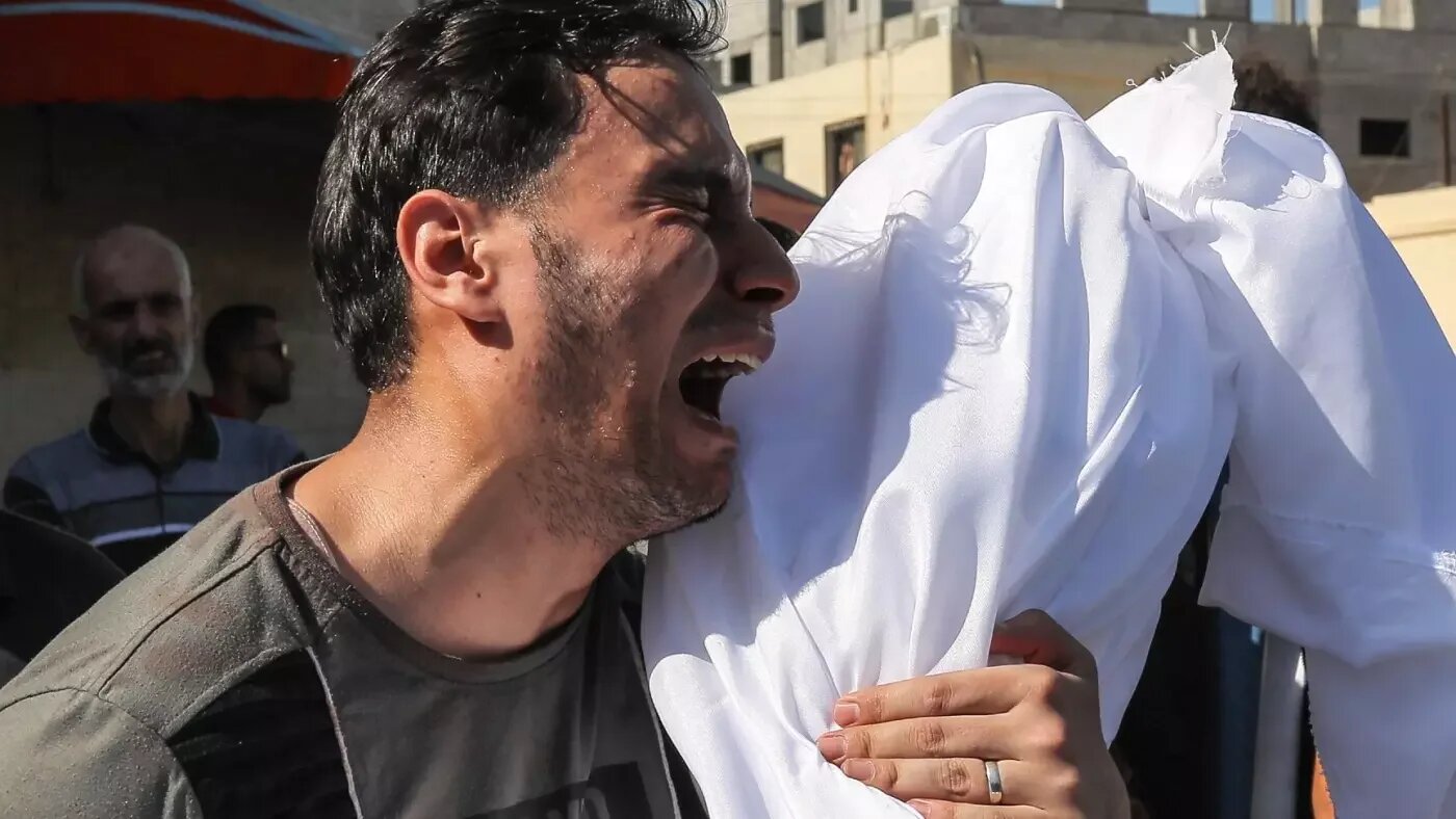 Un père en deuil transporte le corps de son enfant tué dans les frappes aériennes israéliennes, le 15 octobre 2023 (Reuters)