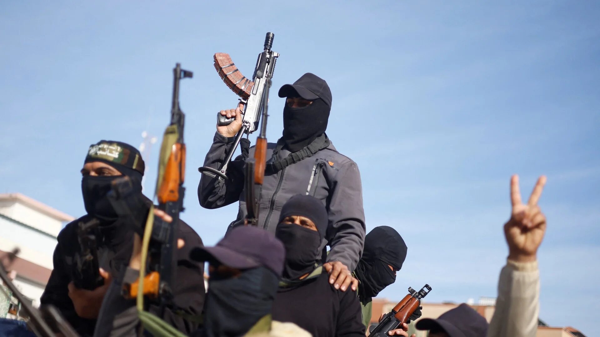 Palestinian fighters celebrate the ceasefire in Khan Younis in the southern Gaza Strip on 19 January 2025 (Reuters/Mohammed Salem)