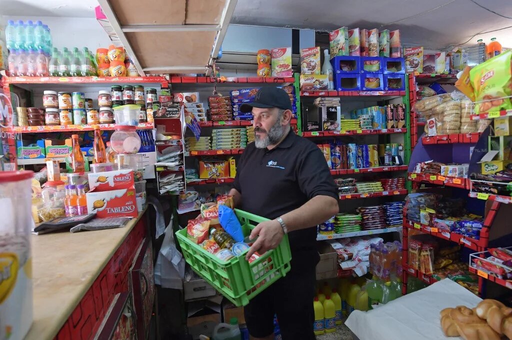 Un employé tunisien d’une épicerie prépare des rations d’aide alimentaire pour les plus démunis, à Tunis le 8 mai 2020 (AFP)