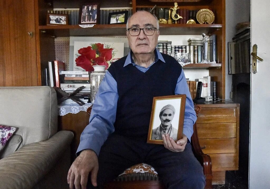 Mohamed Tazir pose, à Alger, le 20 février 2022, avec la photo de son grand-père, disparu en 1957 après son arrestation par l’armée française (AFP/Ryad Kramdi)