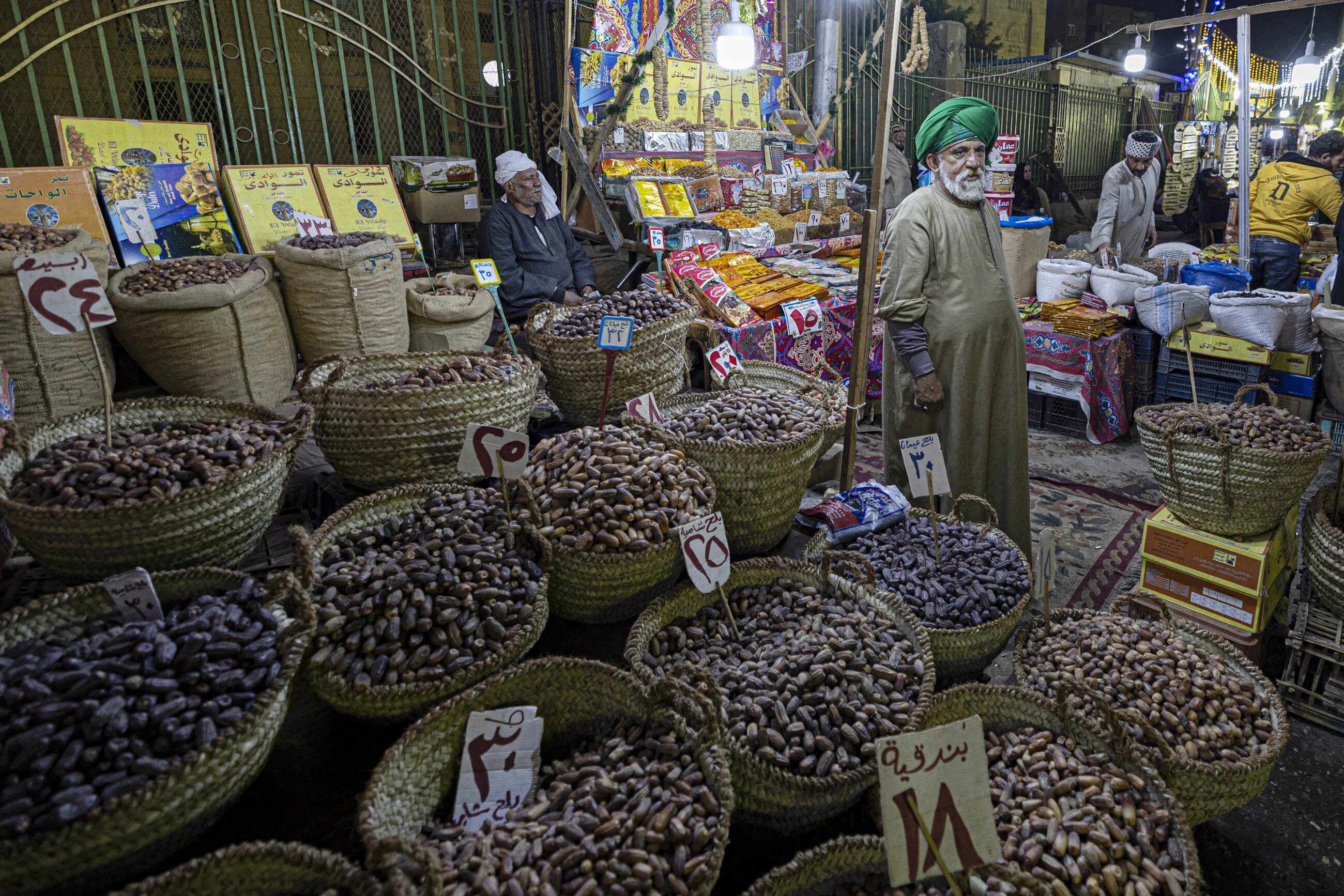 An Egyptian vendor sells dates and dried fruits at a traditional market in the Egyptian capital Cairo's central Sayyida Zeinab district late on 30 March 2022 (AFP)