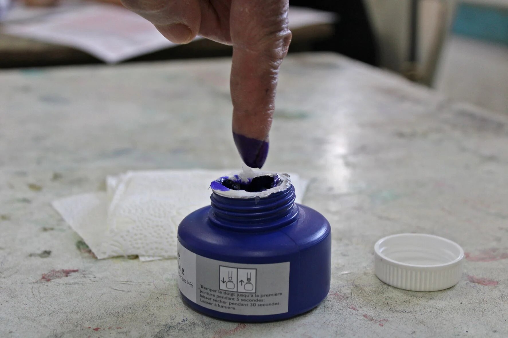 A Tunisian man dips his finger in ink after voting in a referendum on a draft constitution put forward by the country's President, at a polling station in Kasserine, on 25 July 2022 (AFP)