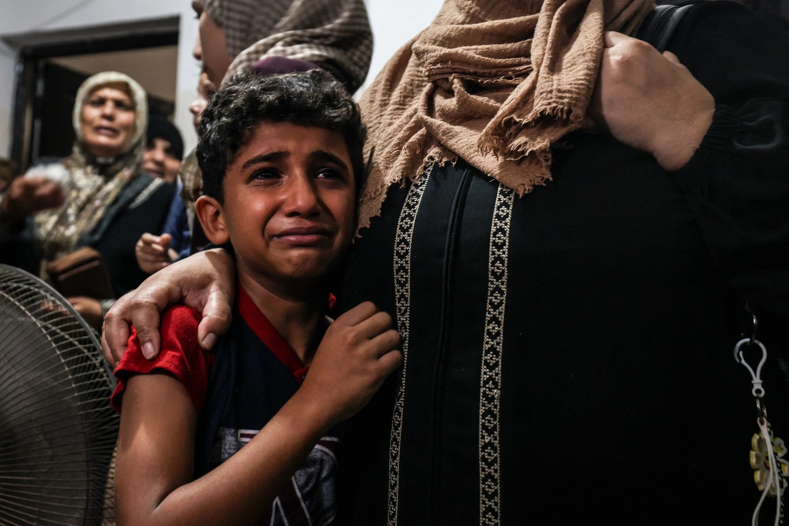 Relatives of a young Palestinian killed during the night in the Jabalia refugee camp in the northern Gaza Strip, react during his funeral in the same camp, on 7 August 2022. (AFP)