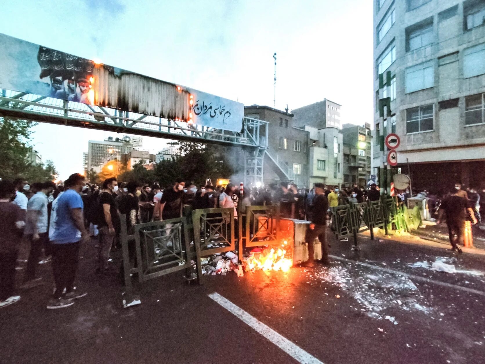 A picture obtained by AFP outside Iran on September 21, 2022, shows Iranian demonstrators burning a rubbish bin in the capital Tehran during a protest for Mahsa Amini (AFP)
