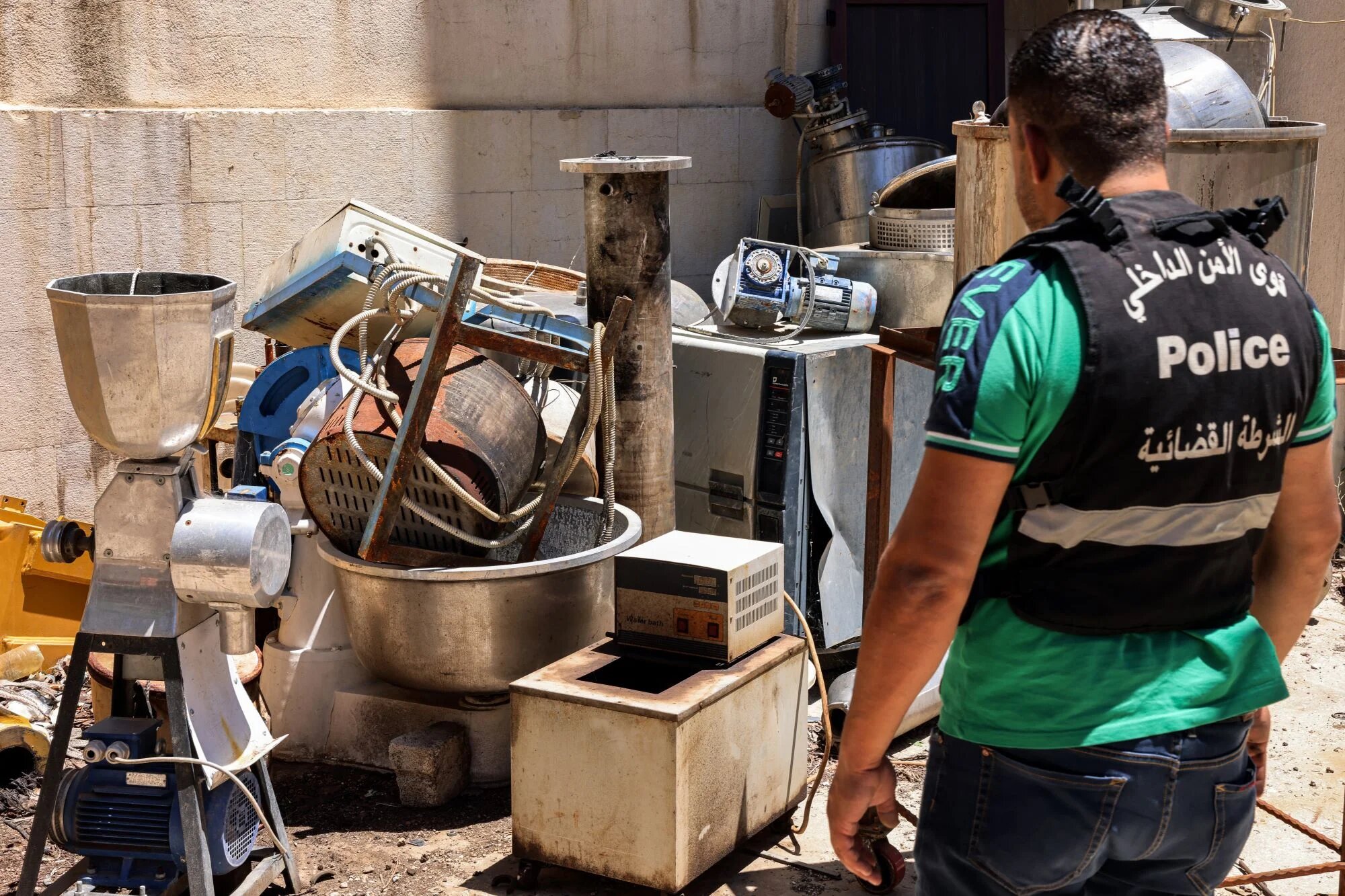 A Lebanese judicial police official inspects confiscated instruments for captagon pill manufacturing at the judicial police headquarters in the city of Zahle in Lebanon's central Bekaa valley on July 21, 2022 (AFP)