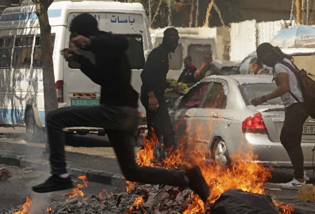 Palestinian protesters confront Israeli forces in Hebron in the occupied West Bank, on 12 October 2022 (AFP)